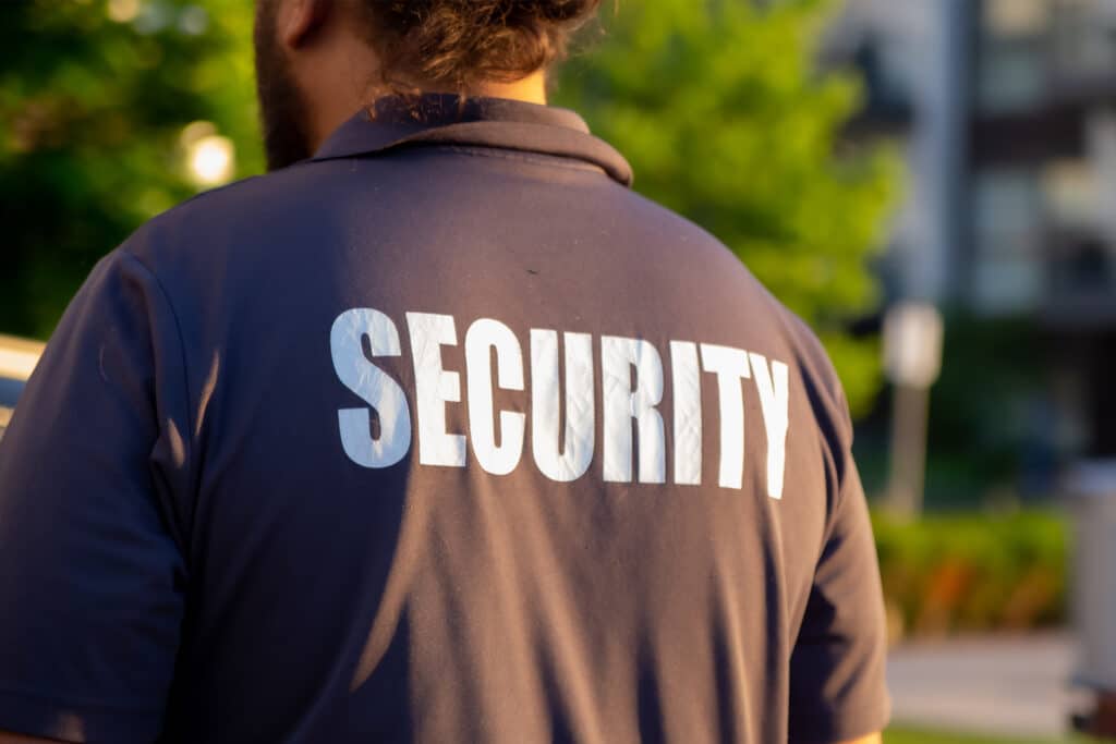 security guard in uniform patrolling outside high-income birmingham home