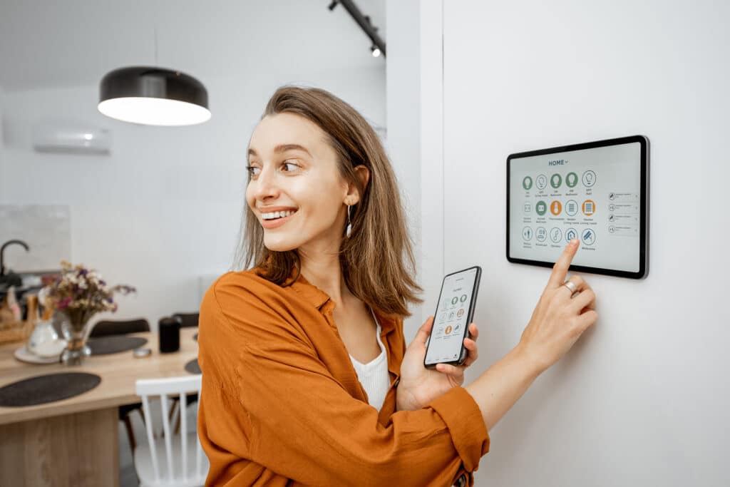 a white woman in a beautiful home using a smart surveillance system via a tablet